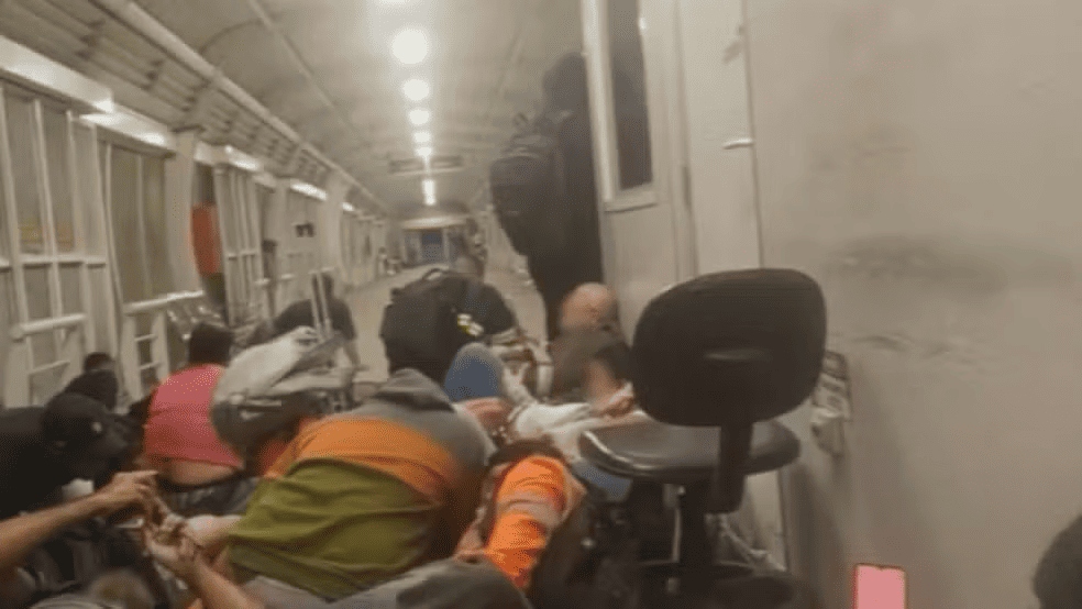 Passageiros abaixados em estação do BRT para se proteger de tiros durante tiroteio no Rio